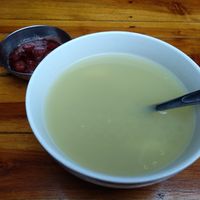 Quinoa and potato soup with a strawberry dessert behind it at Govinda Gopal - Govindas  in Quito