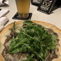 Under all that arugula is an amazing creamy mushroom pizza with Violife! 😍 at Dangerous Minds Brewing Co in Pompano Beach