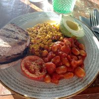 Vegan English breakfast with baked beans, a grilled tomato, scrambled tofu, bread and half an avocado at Natural Kitchen in East London