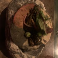 A taco with tortilla made from 3 colors of corn, served on a rock with charcoal underneath  at Teocintle - Tika'aya in Oaxaca