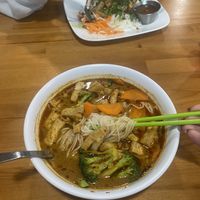 Spicy curry noodle soup with tofu in foreground, tofu rice plate in bg. They have a veggie sauce option instead of fish sauce available!  at My Huong Kitchen in Minneapolis