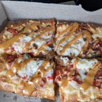 Custom pizza with sausage, pepper and onions, and chipotle drizzle at 4th & State in Columbus