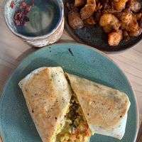 Breakfast burrito, butterfly matcha latte, crispy potatoes at Bearcat Cafe - CBD in New Orleans
