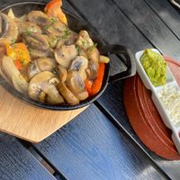 Sizzling mushroom fajitas with side of tomato salsa, guacamole and vegan cheese. at The Quills in Rochester