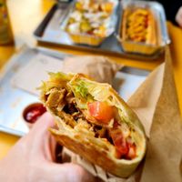 kebap wrap, loaded fries and hot dog in the background at Furahaa - Vegan in Paris