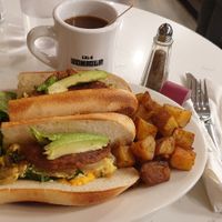 Breakfast sandwich with vegan sausage and potatoes. Coffee with oat milk. at Bonjour Cafe in Boston