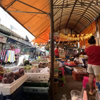 Food stalls with fruit and veg between them   at Art Aharn Jay in Bangkok