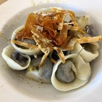 Purple carrot filled capelli with dehydrated chamomile, carrot crisps and lime oil   at Sfoglia Rina in Bologna