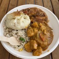 Fried rice with tofu curry and sweet and sour “fish”. Topped with a fried vegan bun at Root Vegetarian in Cairns