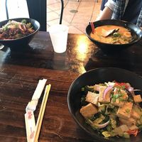 In the front is my diy tofu bowl (vegan) with all the vegan toppings: edamame, sprouts, carrots, corn, lettuce, seaweed salad, and likely more that I'm forgetting. at Bols in Plano