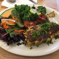 Mushroom, Yellow Pepper and Spinach Frittata served with Italian Herb Balsamic Roasted Roma Tomatoes, Citrus steamed fresh Kale and a Garden Salad. Not pictured - Coconut Pancakes with fresh strawberries and fruit.  at Sluggo's North Vegetarian Cafe in Chattanooga