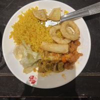 Platter of fried rice, crispy potatoes, onion rings, sweet & sour chicken, mixed vegetables and chicken curry at Su Vegan Buffet in West London