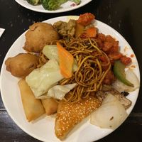 My food including vegetable tempura, mixed veg noodles, sesame toast, spring rolls, sweet-and-sour chicken  at Su Vegan Buffet in West London