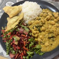 Chickpea curry served with rice, salad and samosas  at Comer Sanar Vivir in Cuenca