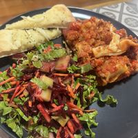 The main from the set lunch- lasagna minus cheese but with soy meat, salad and focaccia  at Comer Sanar Vivir in Cuenca