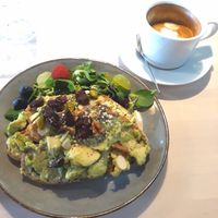 Avocado toast with berries, nuts and seeds. Coffee with soymilk (oat milk and almond milk also available) at But First Coffee in Saumur