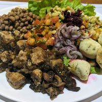 Buffet plate, including tofu with mushrooms, and vegan pão de queijo at Saude na Panela in Salvador