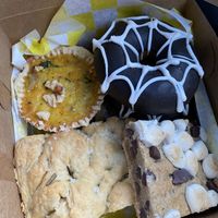 Artichoke and spinach quiche, chocolate spider donut, focaccia bread, s’mores bar  at Yellow Rose Vegan Bakery in Maplewood