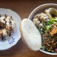 Dish with hummus, beans, salad, bana ganoush and pita at Hummusson in Malmo