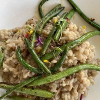 Mushroom risotto - vegan version - w/green beans & edible flowers & microgreens. The risotto is perfect consistency. I believe 3 varieties of mushrooms used including Lions mane.  at Cocha in Baton Rouge