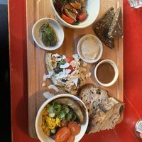 Scrambled tofu, greek salad, hummus, pesto & waffle with homemade vegan nutella, fruits & berries. Rye- & sourdough bread.                   Waffle was too dry for me.   at Flavour Bastards in Copenhagen