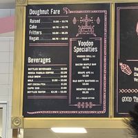 Price menu. In store hand held menus have the pictures and descriptions of donuts. There are also rotating glass cabinets showcasing doughnuts.  at Voodoo Doughnut - Washington Ave in Houston