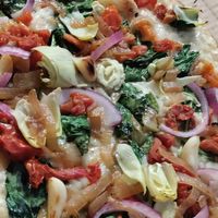 Traditional crust, seasoned olive oil, artichokes, red onion, caramelized onion, sun dried tomatoes, roasted garlic and spinach at Pizza Mio in Florence