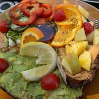 Avocado and fruit toast plate at EM Breakfast Club in Hamburg