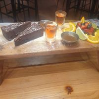 Afternoon tea: Fruit Pot. CLEMENTINE BROWNIE (ve) with chocolate sauce.

Served with 2 shots. at Revolution in Wilmslow