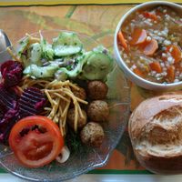 Example of a plate with food from the "Vegane Theke" and the vegan soup of the day, a carrot soup, with a bread roll, from "WOK forU" at Mensa Tarforst in Trier