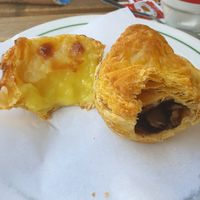 Bitten into nata dessert and mushroom pastry at Pastelaria Tupi in Porto