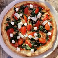 Spinatpizza mit veganem Käse, veganem Feta und Cherry-Tomaten at Trattoria Di Liberto Dick & Doof in Frankfurt