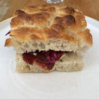 SMOKED PASTRAMI SEITAN LAYERED WITH HORSERADISH AND MUSTARD MAYONNAISE AND PICKLED RED CABBAGE ON FRESHLY BAKED FOCACCIA  at Last Light Coffee in Blackpool