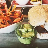 Vegan spelt bun mit Chickpea Patty, iceberg salad, tomatoes, red onions and guacamole 💚 + sweet potato fries. at Le Burger in Wiener Neustadt