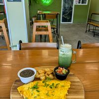 "Omelette" from chickpea flour stuffed with vegan chorizo and vegan cheese, frijoles, salsa and roasted potatoes & green juice at Herbivoro in Cancun