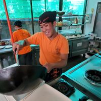 Friendly chef preparing meal in front of us at Pum Thai Restaurant & Cooking School in Phuket
