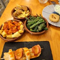 Patatas bravas, pimientos de Padrón and chorizo en vino. at La Vegana Taperia in Malaga