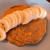 Vegan, gf pancakes topped with banana and peanut butter at O Diplomata in Porto