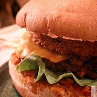 Artisan bread, sun-dried tomato cream, salad, onions, beyond meat steak with Provence herbs, breaded eggplant, zucchini pickles with tarragon, vegan cheddar. Served with fries at Green Gorilla in Montpellier