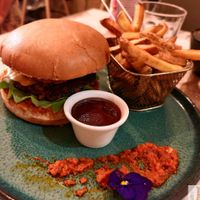 Artisan bread, sun-dried tomato cream, salad, onions, beyond meat steak with Provence herbs, breaded eggplant, zucchini pickles with tarragon, vegan cheddar. Served with fries at Green Gorilla in Montpellier