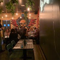 Seating area with beautiful decor and mural paintings at Ras Plant Based in Brooklyn