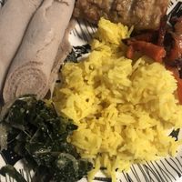 Injera rolls on the left, lentil sambusa on top, rice and different parts of the vegan sampler.  at Ras Plant Based in Brooklyn