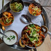 Main; large bowl is Bhindi-do-Pyaza with okra. The 4 smaller ones are from my vegetarian husband. The raita and spinach aren't  vegan in thuis photo. at India Palace in Apeldoorn