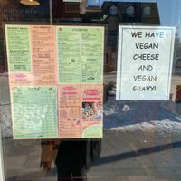 Menu and sign posted on outer window at Aardvark in Banff