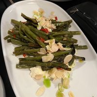 ROASTED GREEN BEANS $16.00 Oven roasted garlic & chilli green beans served in a bed of feta, roasted almonds. (We paid for this extra on top of banquet)   at Nonna's Nightmare in West End