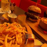 Fries with cheddar cheese, pear burger in the back at The Street  in Prague