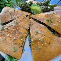 Mushroom Quesadilla- red bell tortilla filled with cheez, 'sauteed' mushrooms & onions, tomatoes & greens.
Served w/ guacamole Add walnut meat for an extra cost well worth it!   at Peace Pies in San Diego