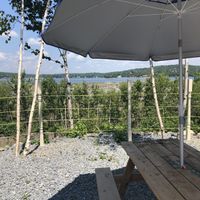 Patio overlooking the water (lots of tables, some with umbrellas for shade) at Booza Emessa in Bedford