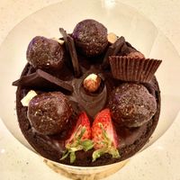 Toppings on the cake: Chocolate cups, bliss balls, chocolate bar pieces, fruit, hazelnuts. Amazing!! at Giselle's Vegan Kitchen in Laguna Hills