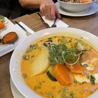 Gelbe Kokos-Curry-Suppe mit Udon Nudeln, Tofu und frischem Gemüse  at Vevi in Vienna